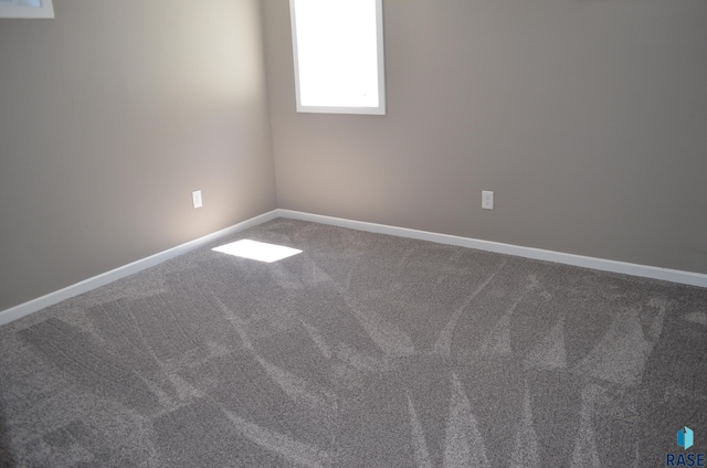 spare room featuring carpet floors and baseboards