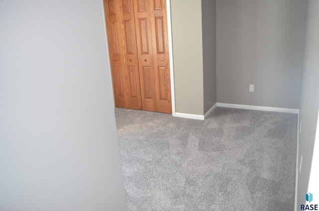 unfurnished bedroom featuring carpet floors, a closet, and baseboards