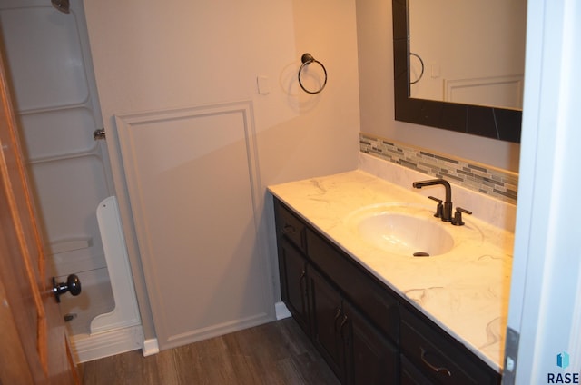 bathroom featuring decorative backsplash, vanity, and wood finished floors