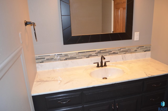 bathroom with tasteful backsplash and vanity