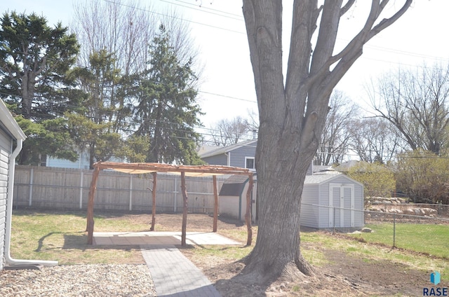 view of yard with a fenced backyard, an outdoor structure, and a storage shed