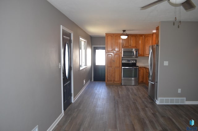 kitchen featuring stainless steel appliances, dark wood finished floors, visible vents, a ceiling fan, and brown cabinets