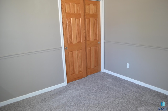 spare room featuring baseboards and carpet