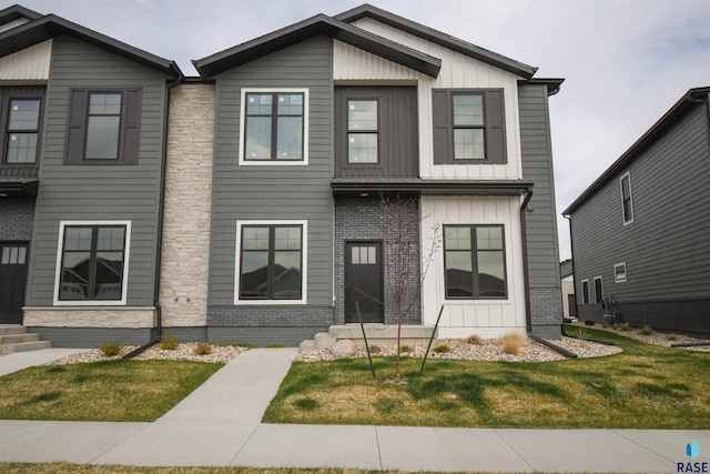 8617 W Shoreline Pl, Sioux Falls, SD 57107 - view of front of home with board and batten siding, entry steps, and a front lawn