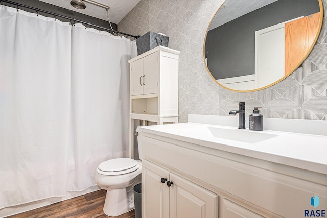 full bath with wallpapered walls, wood finished floors, toilet, and vanity