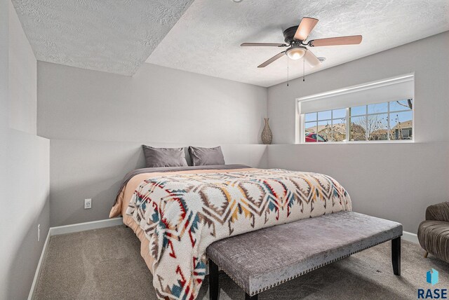 bedroom with a textured ceiling, carpet flooring, and baseboards