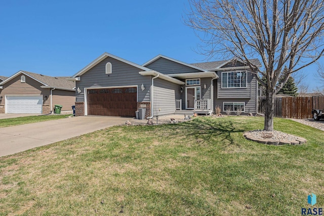 view of front of home featuring fence, driveway, a front lawn, and a garage