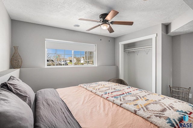 bedroom with ceiling fan, a textured ceiling, and a closet