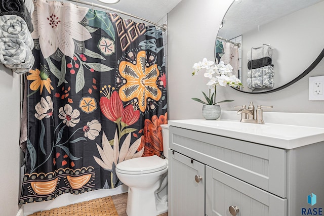 full bathroom with curtained shower, toilet, and vanity