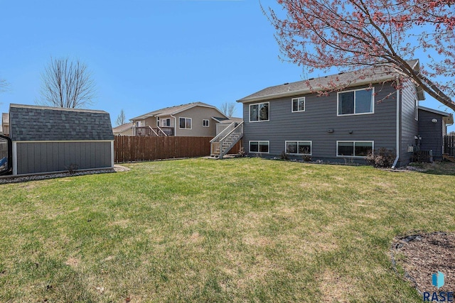 rear view of house with stairway, fence, a storage shed, a yard, and an outdoor structure