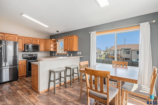 kitchen featuring dark wood finished floors, freestanding refrigerator, lofted ceiling, light countertops, and electric stove