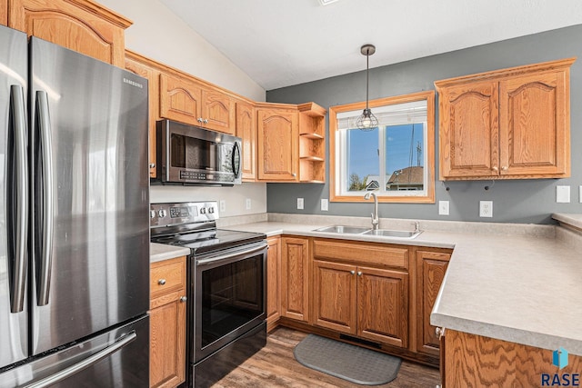 kitchen featuring vaulted ceiling, a sink, stainless steel appliances, light countertops, and dark wood-style floors