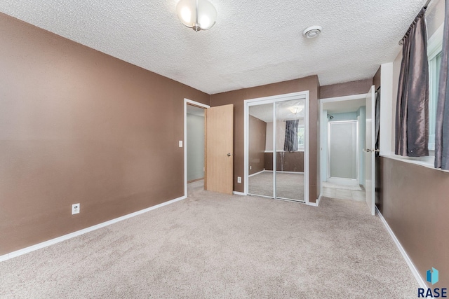 47205 94th St, Sioux Falls, SD 57108 - unfurnished bedroom with baseboards, a closet, a textured ceiling, and carpet