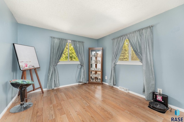 47205 94th St, Sioux Falls, SD 57108 - unfurnished room with baseboards, wood finished floors, visible vents, and a textured ceiling