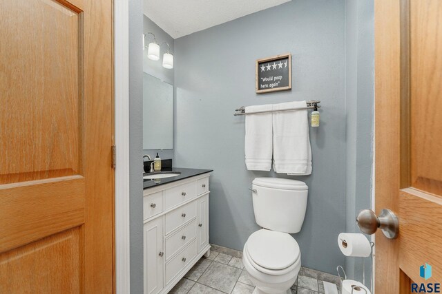 47205 94th St, Sioux Falls, SD 57108 - half bathroom featuring tile patterned flooring, toilet, and vanity