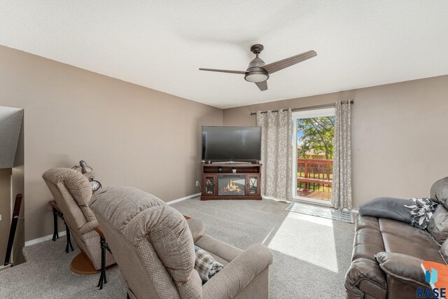 47205 94th St, Sioux Falls, SD 57108 - living room with a glass covered fireplace, carpet floors, a ceiling fan, and baseboards