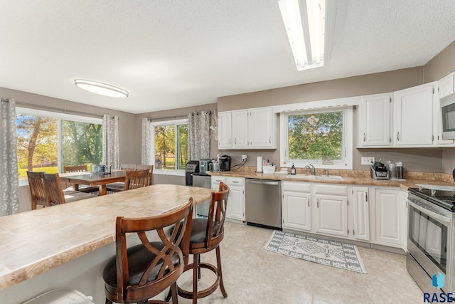 47205 94th St, Sioux Falls, SD 57108 - kitchen featuring white cabinets, light countertops, a sink, and appliances with stainless steel finishes