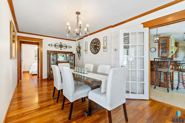 dining room featuring hardwood / wood-style flooring, crown molding, and a chandelier