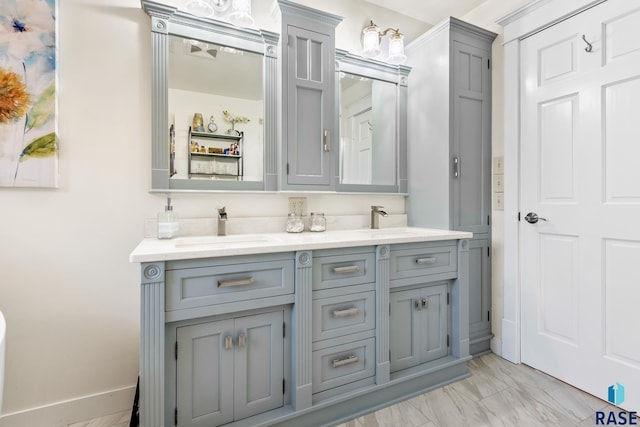 full bathroom with double vanity, marble finish floor, and a sink