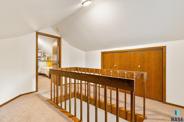 interior space with lofted ceiling, light carpet, and baseboards