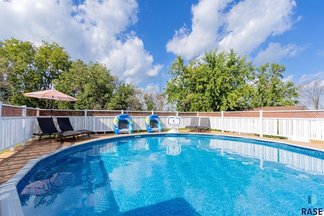 view of swimming pool featuring fence, a deck, and a fenced in pool