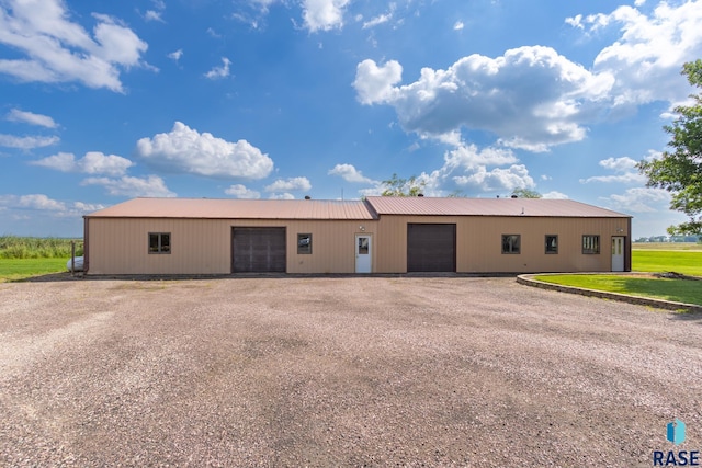 view of pole building featuring a garage and dirt driveway