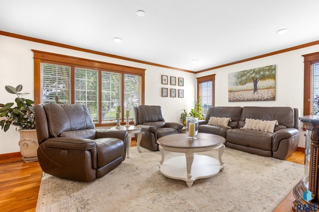 living area with wood finished floors, a healthy amount of sunlight, and crown molding