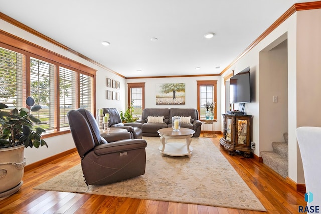 living room featuring wood-type flooring, crown molding, and baseboards