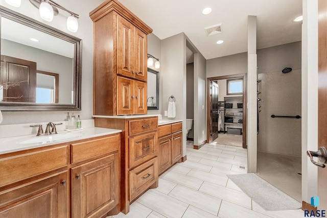 full bath with visible vents, vanity, and a walk in shower