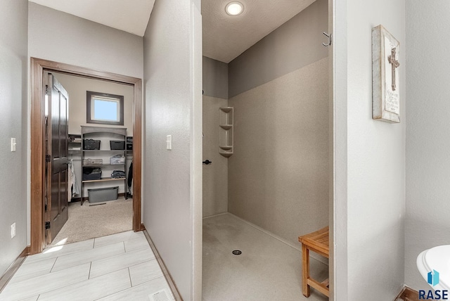 bathroom featuring baseboards and a walk in shower