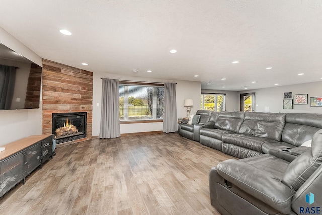 living room with light wood-style flooring, recessed lighting, and a fireplace