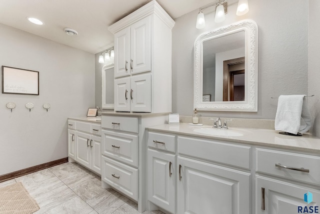 bathroom featuring baseboards, vanity, and visible vents