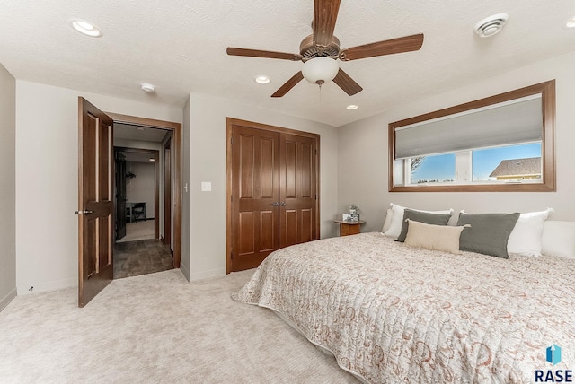 bedroom with light carpet, baseboards, recessed lighting, and a closet