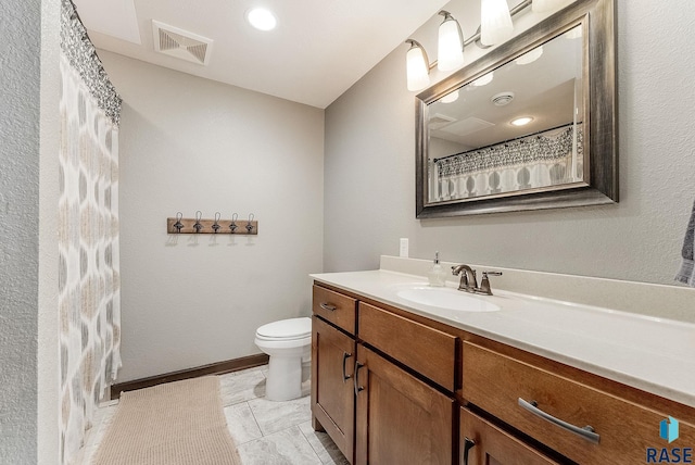 full bathroom with toilet, vanity, and visible vents