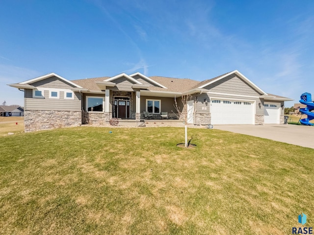 craftsman house with stone siding, an attached garage, a front lawn, and driveway