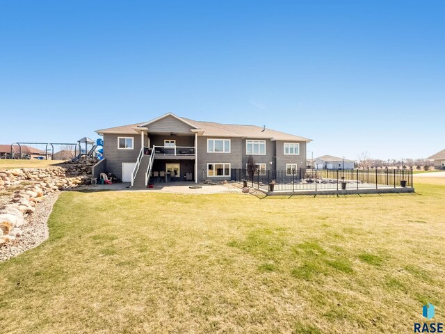 rear view of property featuring a yard, stairway, fence, and ceiling fan