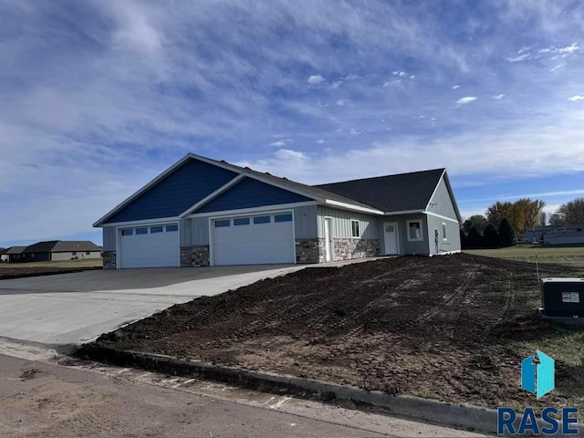 view of front of home featuring an attached garage, concrete driveway, and stone siding