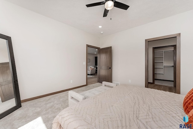 carpeted bedroom featuring recessed lighting, a spacious closet, a ceiling fan, and baseboards