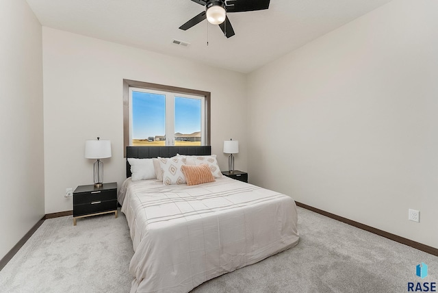 carpeted bedroom with visible vents, baseboards, and ceiling fan