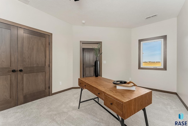 office area featuring visible vents, light colored carpet, and baseboards