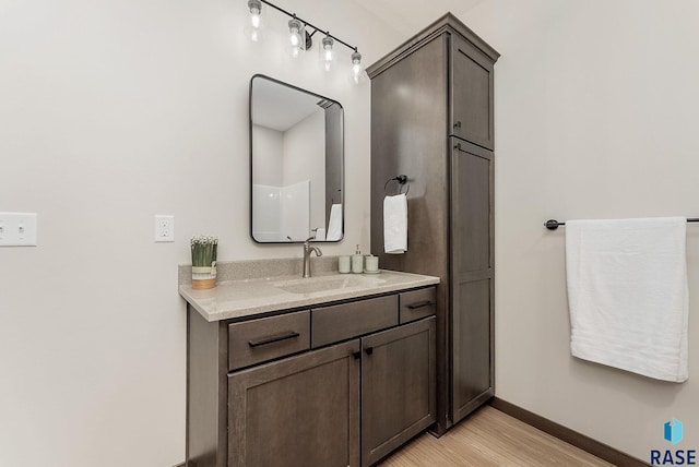 bathroom with baseboards, vanity, and wood finished floors