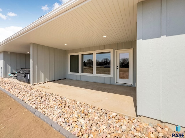 entrance to property featuring a patio area and board and batten siding