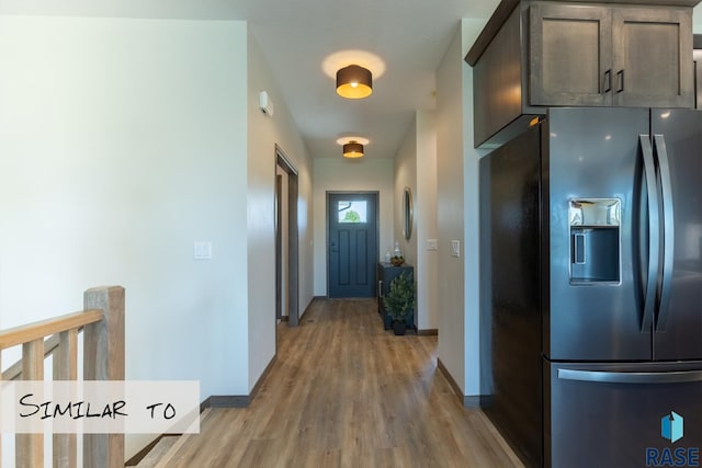 hall featuring baseboards, an upstairs landing, and light wood finished floors