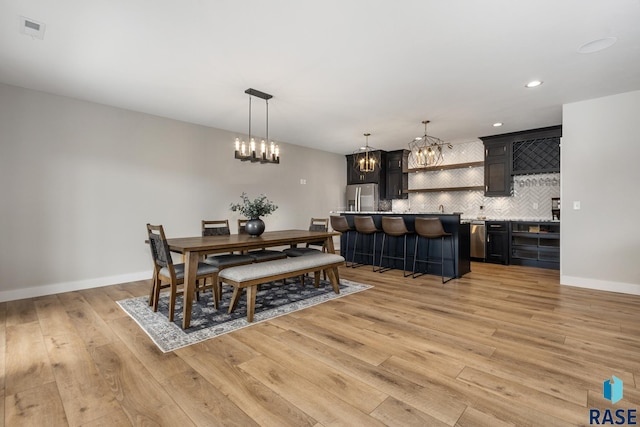 dining room with a chandelier, light wood finished floors, baseboards, visible vents, and recessed lighting