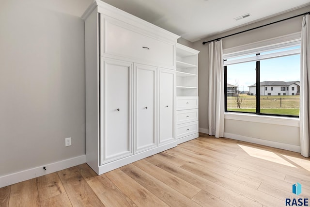 unfurnished bedroom featuring visible vents, baseboards, and light wood-type flooring