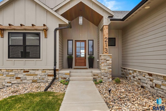 property entrance featuring board and batten siding and stone siding