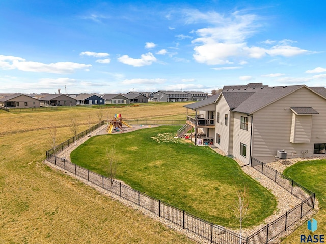 view of yard featuring stairs, a residential view, a fenced backyard, and a playground