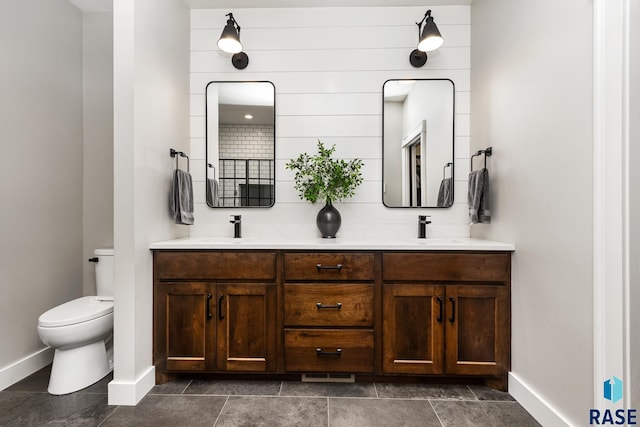 bathroom with toilet, baseboards, and a sink