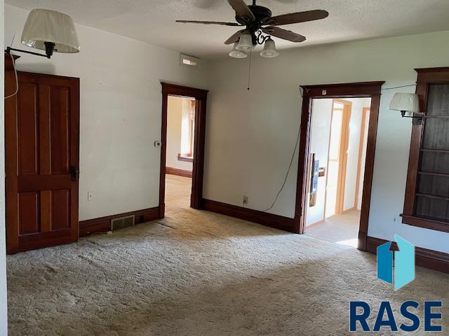 1131 Williams St, Larchwood, IA 51241 - carpeted spare room with ceiling fan, baseboards, and visible vents