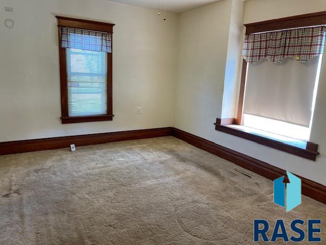 1131 Williams St, Larchwood, IA 51241 - spare room with visible vents, baseboards, and carpet floors